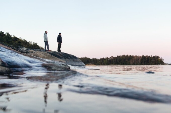 kaksi henkilöä seisoo rannalla